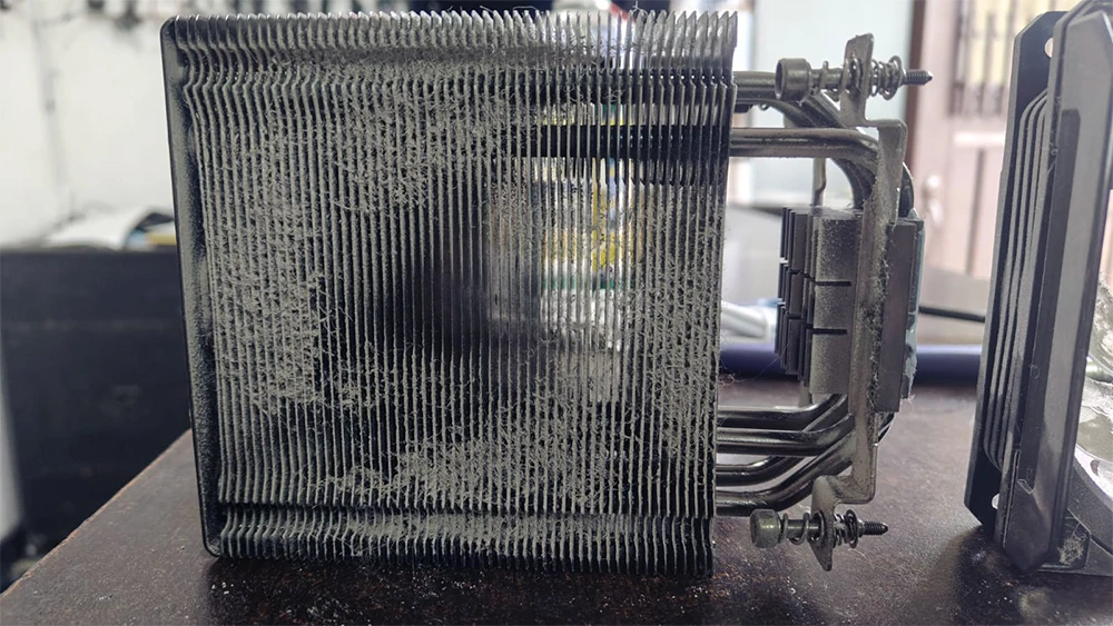 Primer plano del chip procesador gráfico (GPU) sobre la placa electrónica, cubierto con residuos de pasta térmica antigua antes del proceso de limpieza técnica